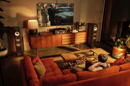 Vintage stue med rød sofa, træ-TV-møbel, højttalere, planter, lampe, billede af gammel bil på væggen