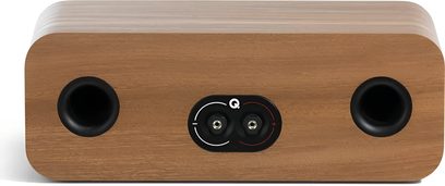 Q Acoustics 3090c centerhøjttaler set bagfra, rektangulært kabinet med afrundede hjørner i lyst træfinér, to sorte runde basreflekshuller på hver side af en sort terminalplade med stereo-tilslutninger markeret med rød og hvid