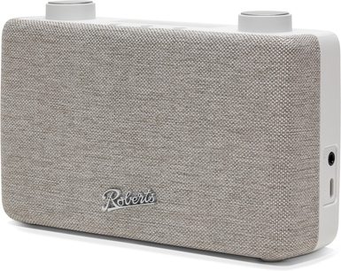 Radio de sobremesa Roberts Play 11 en plástico blanco con frontal de tela color crema, vista desde tres cuartos delantera derecha, equipada con dos botones circulares en la parte superior y puertos laterales.