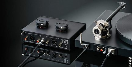Černý gramofon s raménkem a externím audio boxem, pohled zezadu s konektory RCA a XLR