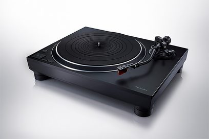 Juoda „Technics SL-1500CEG-K" aukštos kokybės hi-fi vinilinė plokštelių sistema, matoma iš viršaus ir šiek tiek nuožulniai, matomos pagrindinis diskas ir nuskaitymo galvutė