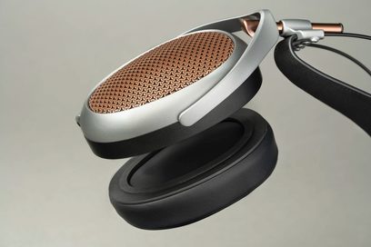 Åbne trådbundne hi-fi-hovedtelefoner med kobberfarvet ydre gitter, mat sort hovedbøjle, cirkulære ørekopper og sorte puder set fra siden