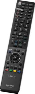 Sort Sharp Aquos fjernbetjening med nummererede knapper, retningspile, farvede knapper og diverse funktionsknapper