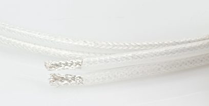 Nærbillede af et hvidt QED Silver Anniversary XT-lydkabel med flettet overflade, detaljeret tekstur og skinnende overflade