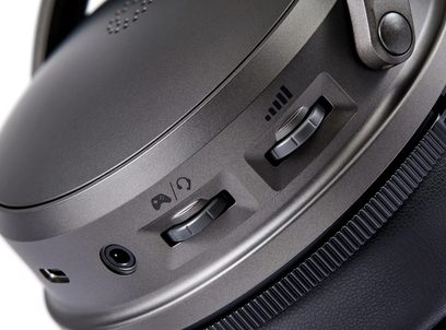 Audeze Maxwell 2 PlayStation gamingheadset grå close‑up af ørekop med knapper til lydstyrke og spil‑chat‑miks, jackstik