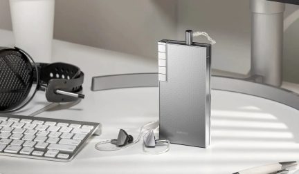 Silberner Astell&Kern-Audioplayer mit kabelgebundenen In-Ear-Kopfhörern auf weißem Schreibtisch