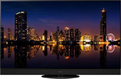 Panasonic TX-55MZ1500E-fladskærm, der viser et natligt vue af oplyste skyskrabere og deres spejling i vandet