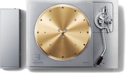 Hi-fi vinylspelare Technics SL-1000R sedd ovanifrån med cirkulär guldfärgad tallrik, silverfärgad tonarm och rektangulärt hölje till vänster