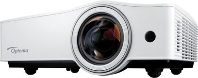 Optoma ZX210ST hvid videoprojektor, set forfra, centreret linse omgivet af en sort ring, højttalerrille til højre