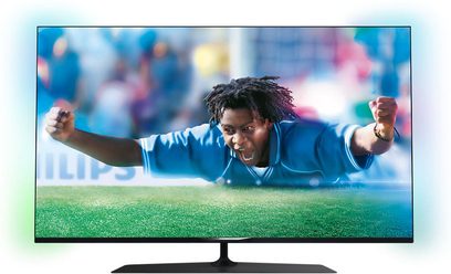 Philips 55PUS7809 fladskærms-TV, der viser en sort fodboldspiller i aktion på en bane, set forfra