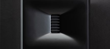A black rectangular structure with a conical interior and horizontal grilles in the center