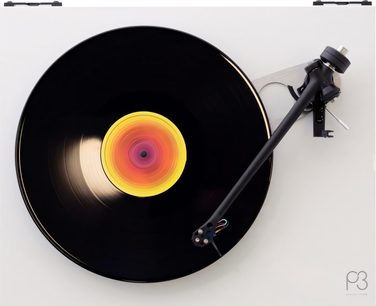 Toca-discos Rega Planar 3 com célula Nd5, vista de cima, prato preto, disco de vinil preto, etiqueta central colorida, braço de leitura preto