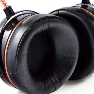 Audeze LCD-5s hi-fi austiņas tuvplānā, melnas ādas apkārt ausīm aptveroši spilventiņi ar vara joslu