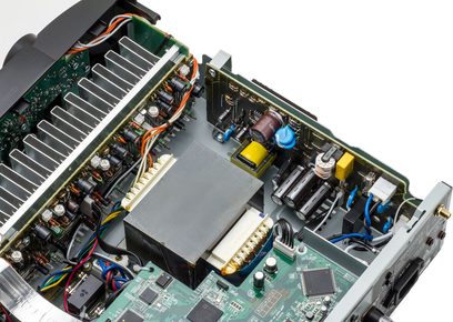 Innenansicht eines schwarzen Marantz NR1609 Heimkino-Verstärkers mit elektronischen Komponenten auf einer grünen Leiterplatte