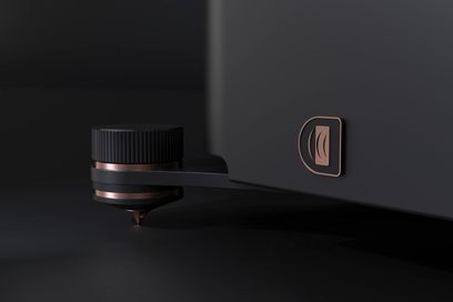 Gulvhøjttaler R7t med sort tekstureret cirkulær fod, kobberfarvet metalindsats, konisk spids og rektangulært kobberlogo på sort overflade