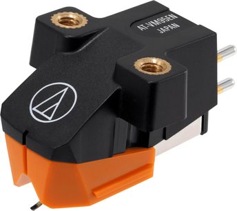 Cell for Audio Technica AT-VM95EN vinyl plate i svart og oransje plast med messinggjenget innsatser, hvitt logo og to metallstifter bak, sett fra høyre forside i perspektiv