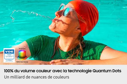 Imagine digitală multicoloră, vedere pe tot cadrul, pentru televizorul high-definition Samsung TQ75Q7F4 2025 de la Samsung, prezentând o persoană cu o căciulă roșie și ochelari transparenți care scuipă apă turcoaz într-o piscină, cu logo-uri și text explicativ în limba franceză