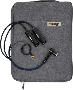 Pohled shora na kabel Thorens PhonoConnect PHS 150 DIN-XLR o délce 1,5 m v černé barvě s textilním opletením v modro-černém provedení, vybavený dvěma černými kovovými XLR konektory, ohnutým DIN konektorem a uzemňovacím vodičem s pozlacenou očkem, položený na šedém látkovém pouzdře.