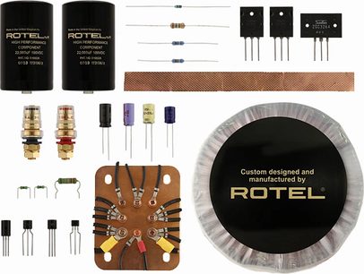 Wzmacniacz mocy Rotel RMB-1504 w kolorze czarnym, 2 duże czarne kondensatory, komponenty elektroniczne, złącza i zaciski przyłączeniowe
