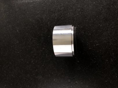 Glänzender metallischer Zylinder mit zentraler kreisförmiger Rille auf schwarzem Hintergrund, Frontalansicht, Franc Audio Accessories Ceramic Disc TH