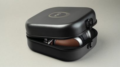 Åbne kablede hi-fi-hovedtelefoner Meze Audio Poet delvist synlige i en sort, let åben hård etui med mat overflade