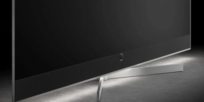 Loewe Stellar 83 DR+ fekete televízió, közeli nézet alsó sávval és szögletes ezüst talppal