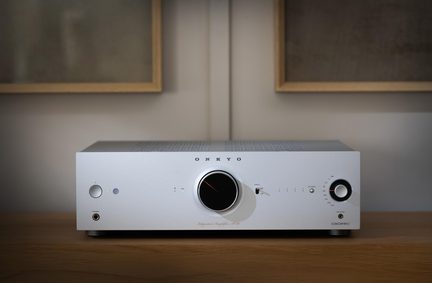 Hi-Fi підсилювач Onkyo, срібляста алюмінієва передня панель, велика центральна чорна ручка гучності, фронтальний роз’єм для навушників 6,35 мм, вид спереду