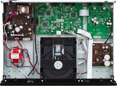 Sisäkuva avoimesta mustasta Denon DCD-900NE CD-soittimesta, jossa näkyvät vihreät elektroniikkapiirit ja lukulaite
