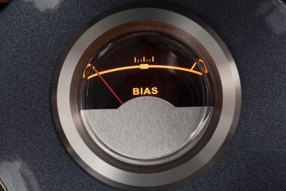 Närbild framifrån på den cirkulära BIAS-mätaren i glas och silverfärgad metall, bakgrundsbelyst i orange, integrerad i Cayin CS-845A Reference silver rörförstärkare