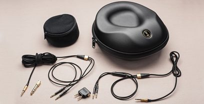Meze Audio 99 Classics Valnød/Guld lukkede hi-fi-hovedtelefoner, set forfra og fra siden, med kabler og jackadapter, på beige baggrund