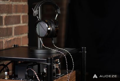 Åben hovedtelefon Audeze LCD-5 i aluminium og sort læder, med planare magnetiske transducere, placeret på sin holder