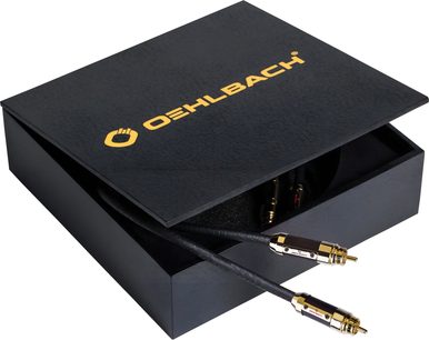 Tredjehånds fugleperspektiv af en sort, rektangulær æske med gylden skrift, delvist åben, hvorfra et sort Oehlbach Black Connection Master analogt RCA-lydkabel med flettet kappe og guldbelagte metalstik stikker ud.