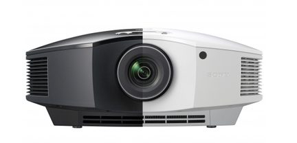 Grå og sort videoprojektor set forfra med centreret objektiv og ventilationsriste på siderne
