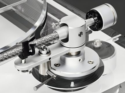 Nærbillede i let fugleperspektiv af en sølvfarvet tonearm i aluminium med grå flettet rør, sort og sølv cylindrisk vægt, sort løftearm og drejelig metalbase